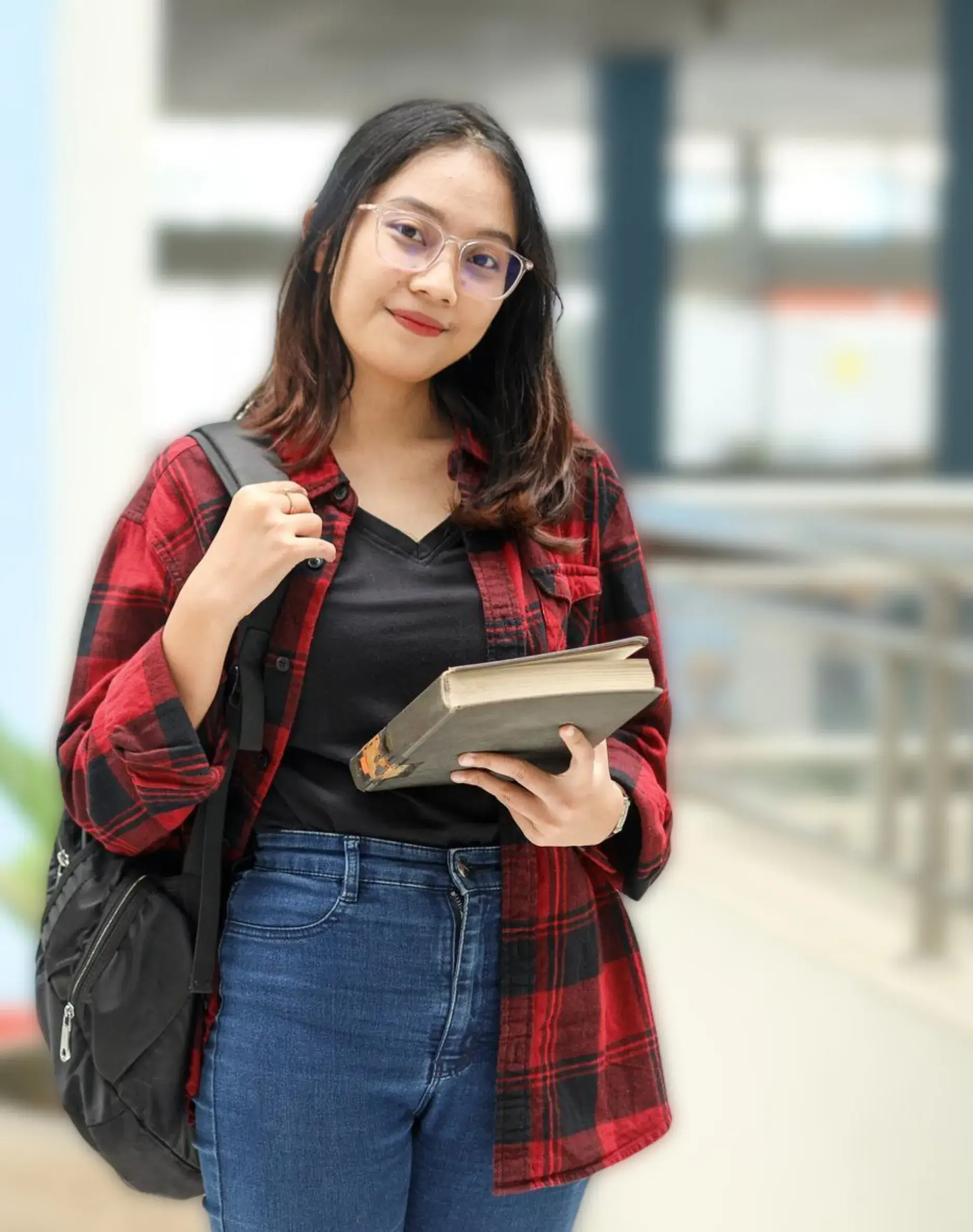 Confident young female student in red plaid shirt and glasses carrying a book and backpack, ready to learn Forex, Crypto, and digital skills at GS Trainings Pakistan.